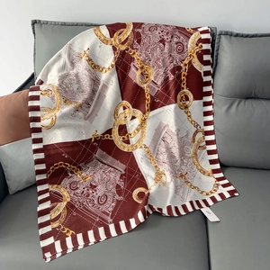 Detail view of the vintage chain and carriage print on a red and gold cotton linen scarf