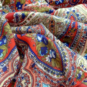 Detail shot of multicolor paisley pattern and soft fabric texture on a large square scarf