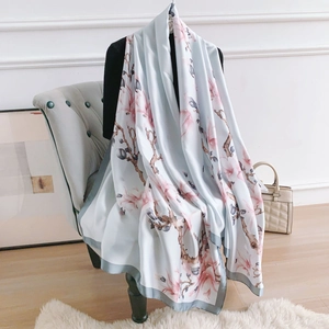 Elegant light blue magnolia floral silk scarf shawl draped on a mannequin for women