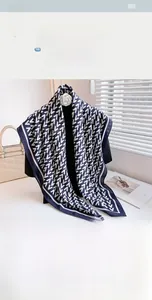 Detail of blue and white geometric V-pattern scarf with navy border and 110cm size tag