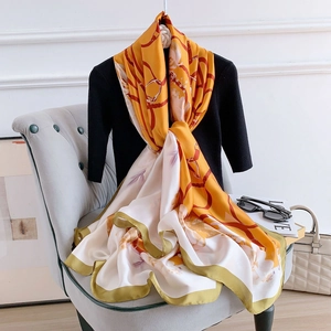 Silk-like scarf with equestrian chain and floral print draped on a mannequin