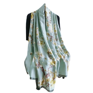 Elegant magnolia floral scarf in light green silk with premium dark green stitched edges