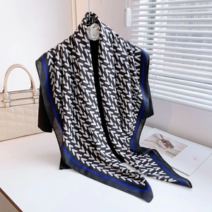 Elegant black and white geometric pattern scarf shawl with dark blue border on a hanger