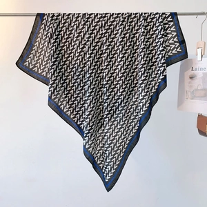 Detail of blue and white geometric V-pattern scarf draped on a metal hanger