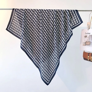 Detail of navy and white scarf with V-pattern hanging on metal bar for indoor display