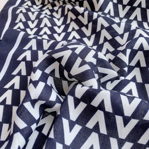Elegant black and white scarf featuring a repeating V-shaped geometric pattern and soft texture