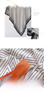 Detail of soft polyester silk scarf with black white geometric patterns and orange borders