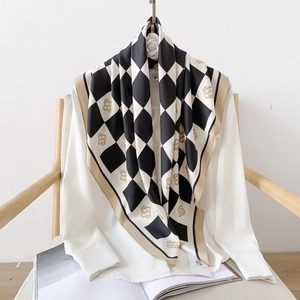 Detail of silk-texture checkered scarf with gold letter print on white shirt