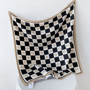 Detail of checkered silk scarf featuring gold abstract patterns and champagne border