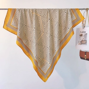 Detailed close-up of geometric pattern scarf with black lines and mustard yellow border