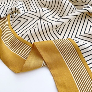 Silk scarf with mustard yellow and black geometric patterns in twill fabric texture