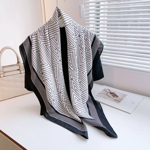 Modern geometric pattern scarf in black and white hanging with a stylish white handbag