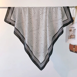 Detail of large square scarf featuring black and white geometric triangle patterns