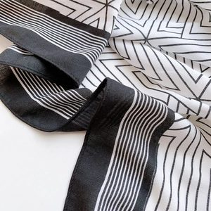 Macro view of geometric black and white scarf featuring detailed herringbone weave texture