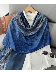Dettaglio di sciarpa in cotone e lino con motivo paisley blu sopra camicia bianca