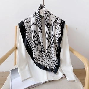 Détail d'un foulard en soie bleu marine à motifs géométriques sur une chemise blanche