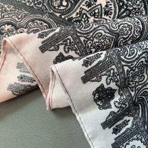 Dettaglio dello scialle in cotone rosa con motivo paisley e cuciture di precisione