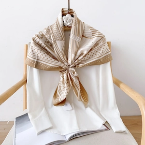 Gros plan d'un foulard en soie aux motifs géométriques bleu marine et dorés