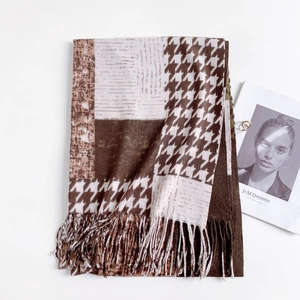 Detail of classic houndstooth scarf with tassels in brown, camel and beige tones