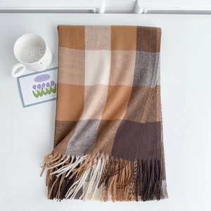 Detail of soft checkered scarf with tassels in brown, camel and beige tones