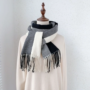 Dettaglio della sciarpa in cashmere bicolore nero e bianco con nappe morbide