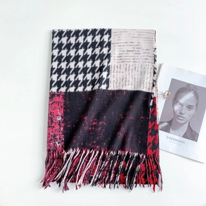 Flat lay of houndstooth patchwork scarf with long fringes, magazine and gold ring detail