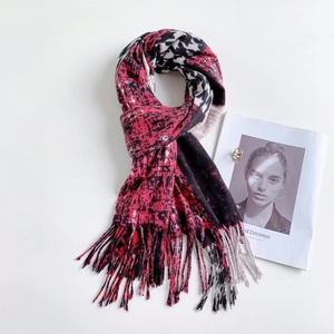 Detailed close-up of houndstooth cashmere shawl with fringe trim in red and black