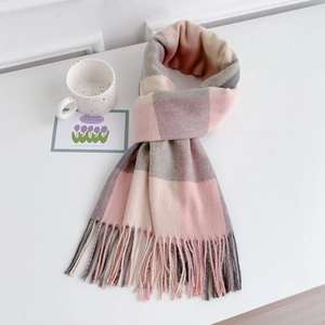 Detail of soft plaid scarf with tassels in pink and grey tones for autumn warmth