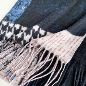 Close-up of patchwork houndstooth scarf with soft fringe and mixed pattern textures