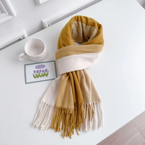 Detailed texture of dual-tone cashmere-like scarf with herringbone pattern and fringe edges