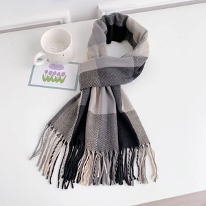 Close-up of thick plaid scarf with long tassels and soft cashmere-like texture fabric