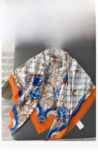 Detailed view of large square scarf featuring floral patterns and orange tassels on fabric