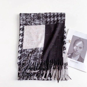 Close-up of black and white houndstooth scarf with long fringe details and soft texture