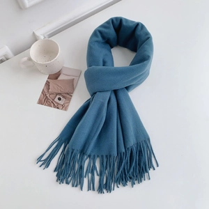 Close-up of soft blue cashmere-feel winter scarf featuring delicate fringe edge details