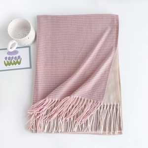 Detail of pink and beige cashmere-style scarf with fine geometric weave and soft fringe trim