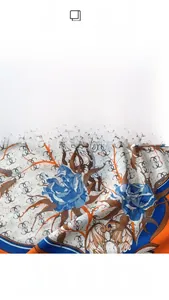 Detail view of blue rose floral pattern and G-logo monogram on thin fashion scarf