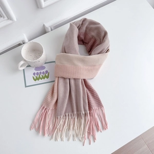 Detail of herringbone weave and fringe on pink patchwork scarf in a cozy setting