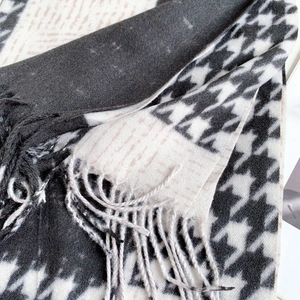 Detailed view of winter houndstooth scarf showing soft cashmere texture and fringe tassel edge