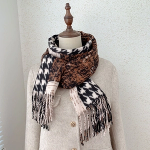 Detail of cashmere-like scarf showing black and white houndstooth and leopard patchwork pattern