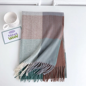Dettaglio della sciarpa a quadri arcobaleno con frange e decorazione tazza minimalista
