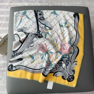 Detailed close-up of patterned square scarf with floral motifs and fringed edges