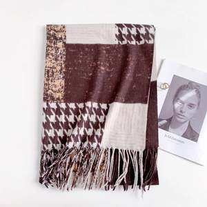 Detail view of houndstooth and leopard print scarf with long tassels for winter