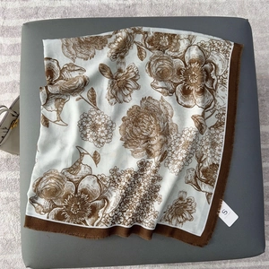 Macro view of floral print scarf with large brown blossoms and solid dark borders