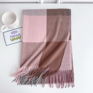Dettaglio della trama della sciarpa a quadri arcobaleno con eleganti nappe su sfondo bianco