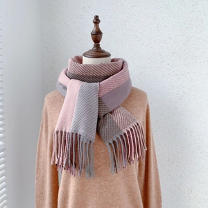 Dettaglio della sciarpa a quadri rosa, grigio e marrone con lunghe frange