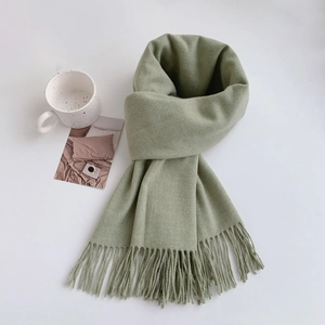 Detailed view of sage green winter scarf with soft cashmere-like texture and fringed edges