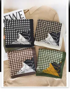 Posa piatta di foulard quadrati pied de poule in vari colori su sfondo camicia beige