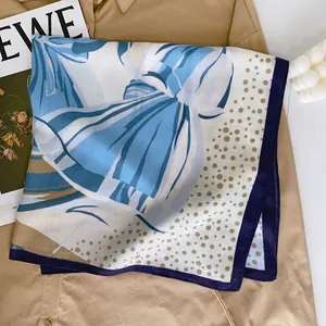 Elegant blue and beige velvet square silk scarf with polka dot patterns on a trench coat