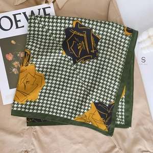 Dettaglio del foulard quadrato in seta con motivo pied-de-poule e stampe di rose gialle