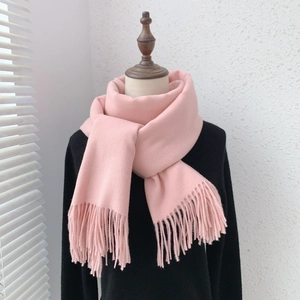 Detail of soft pink faux cashmere scarf showing thick texture and fine fringe tassels